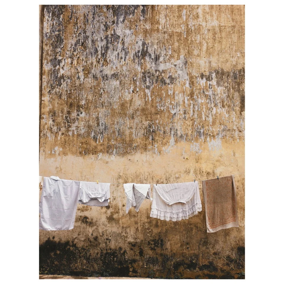 Laundry hanging against a textured ochre wall
