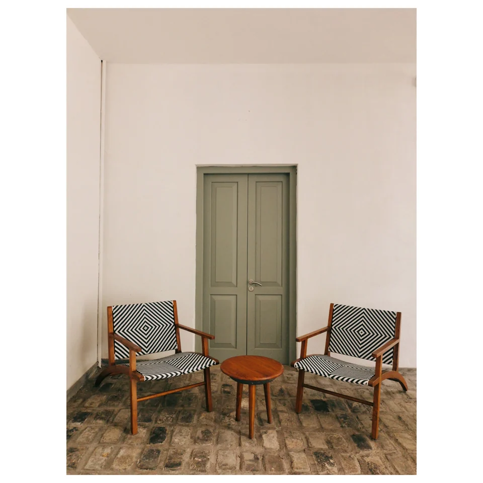 Two chairs beside a muted green door