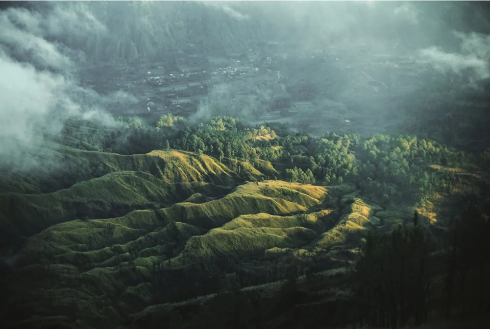 Green ridges beneath a dramatic cloud-filled sky