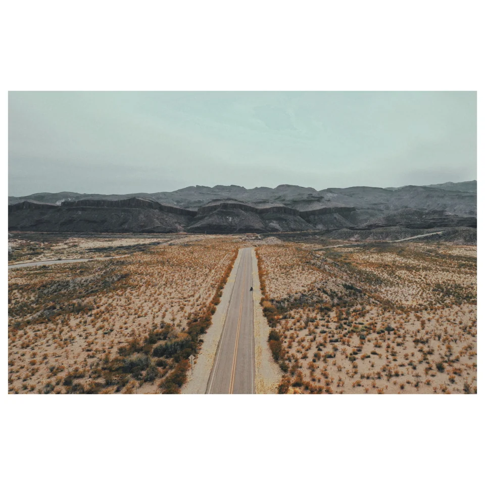 A road running through a broad desert landscape