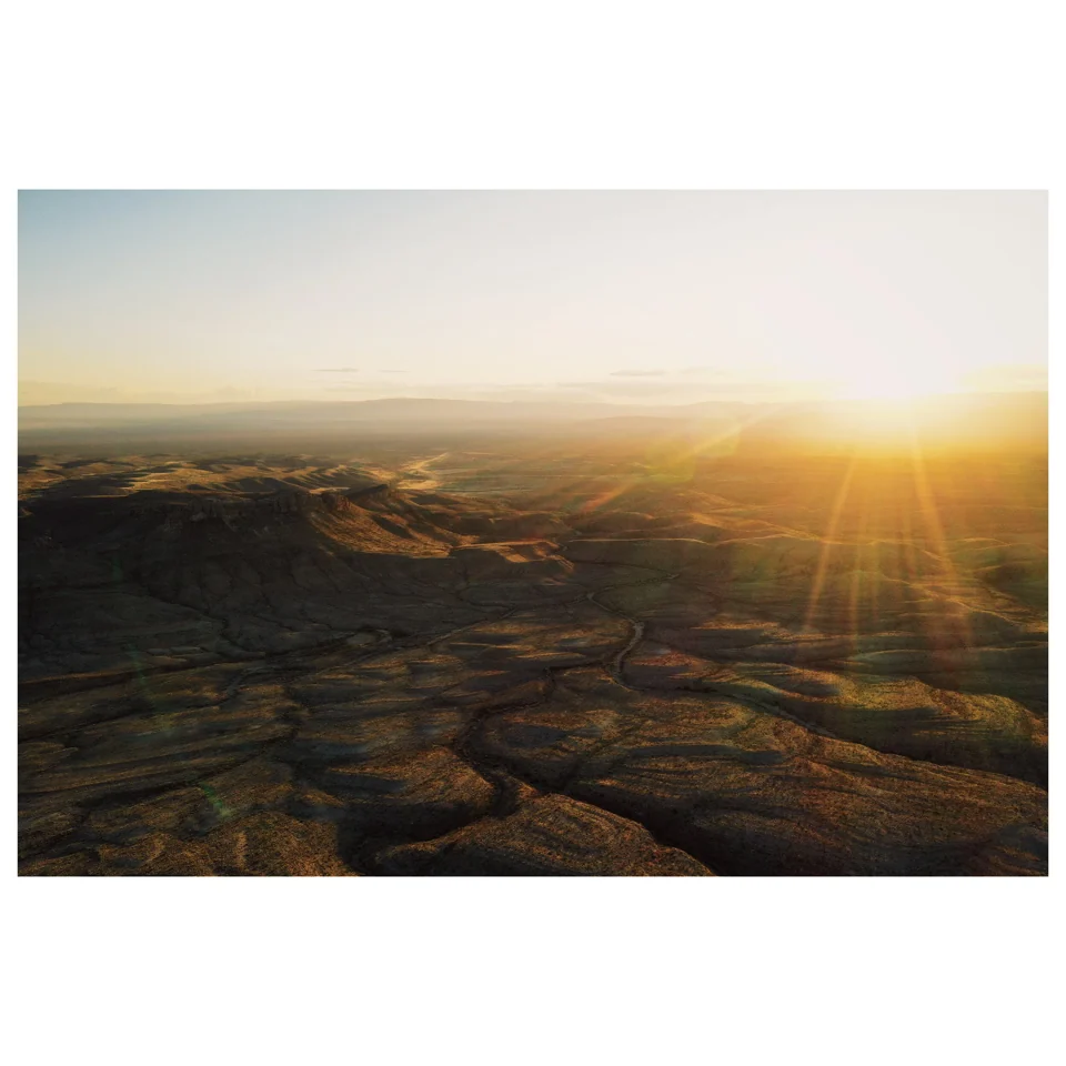 Low sunlight over a rocky desert plain