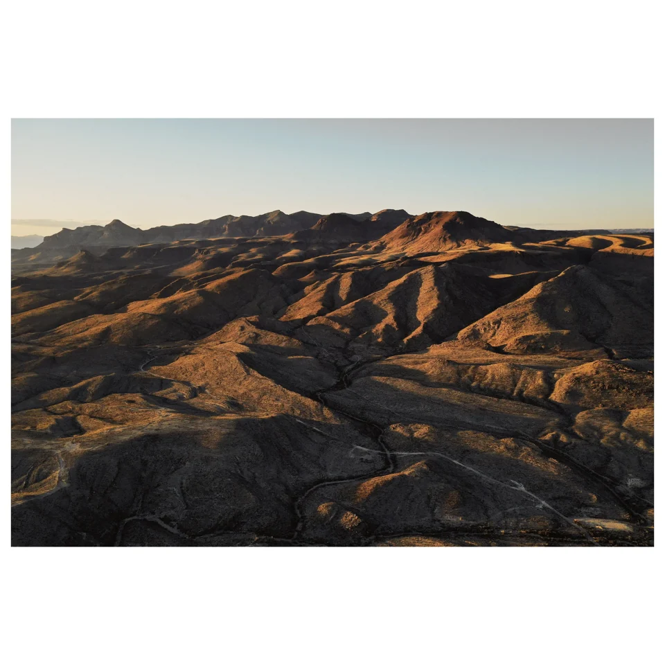 Warm evening light across folded desert hills