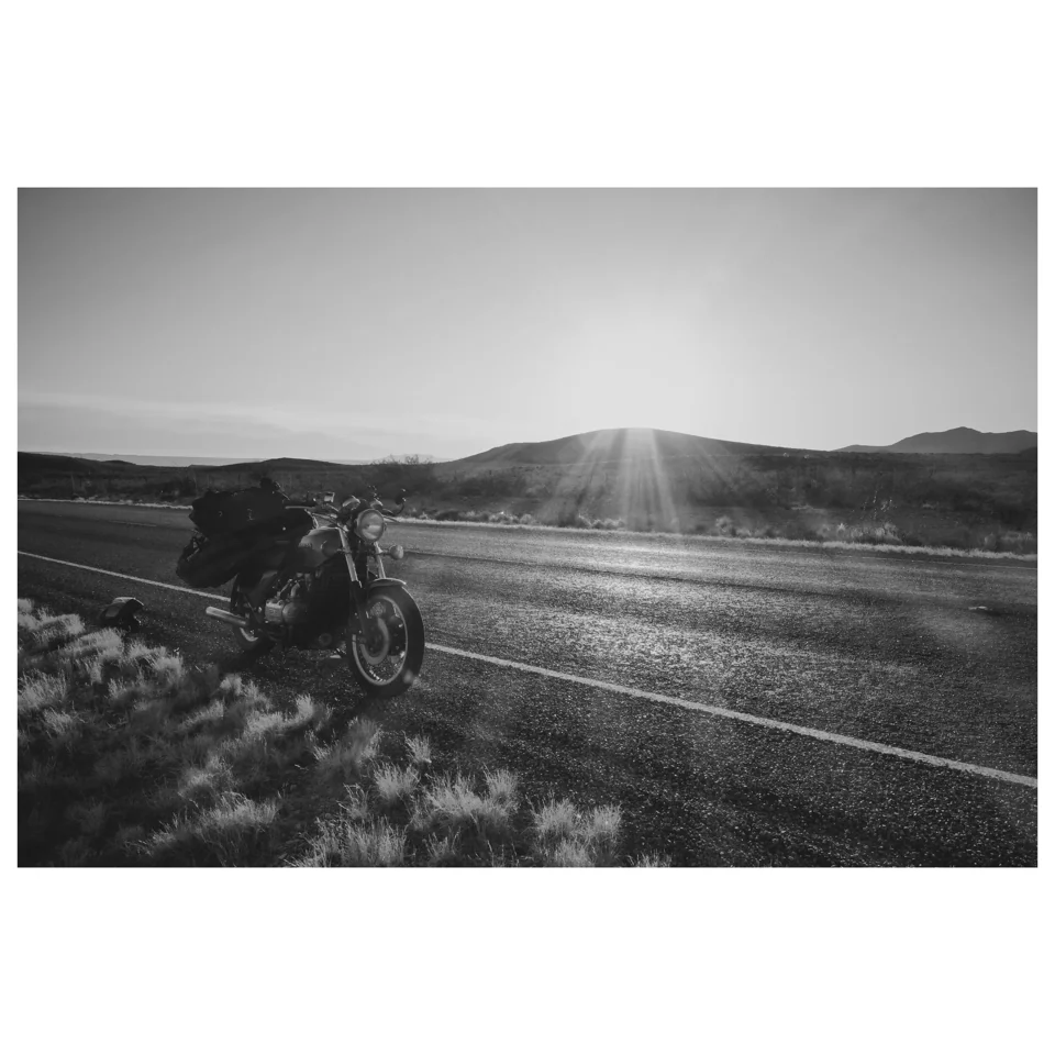A motorcyclist on an open road in black and white