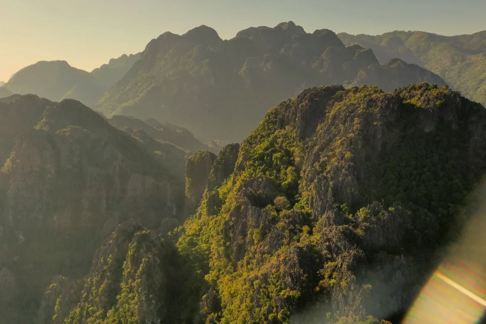 Steep forested mountains in warm light