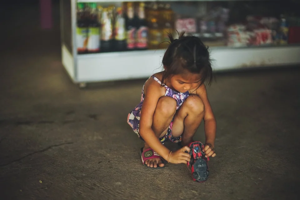 A child playing beside a shopfront