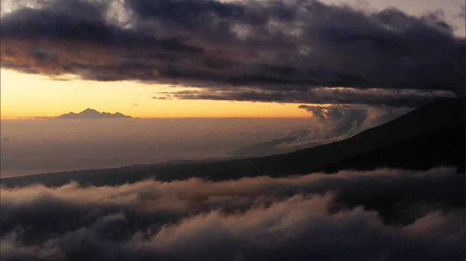 A dark cloud bank above a glowing horizon