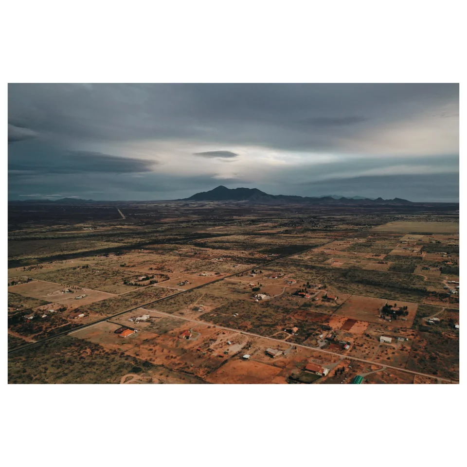 A broad arid landscape beneath storm clouds
