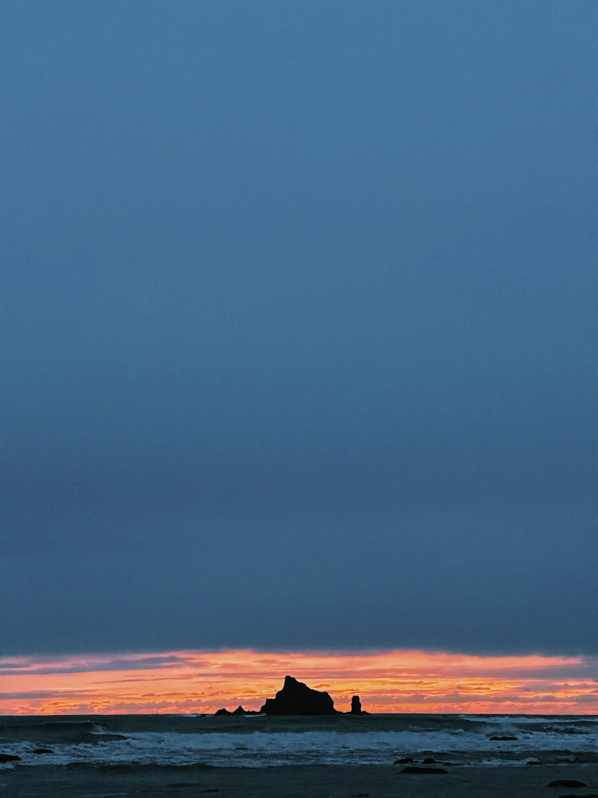 A narrow orange horizon beneath a deep blue sky