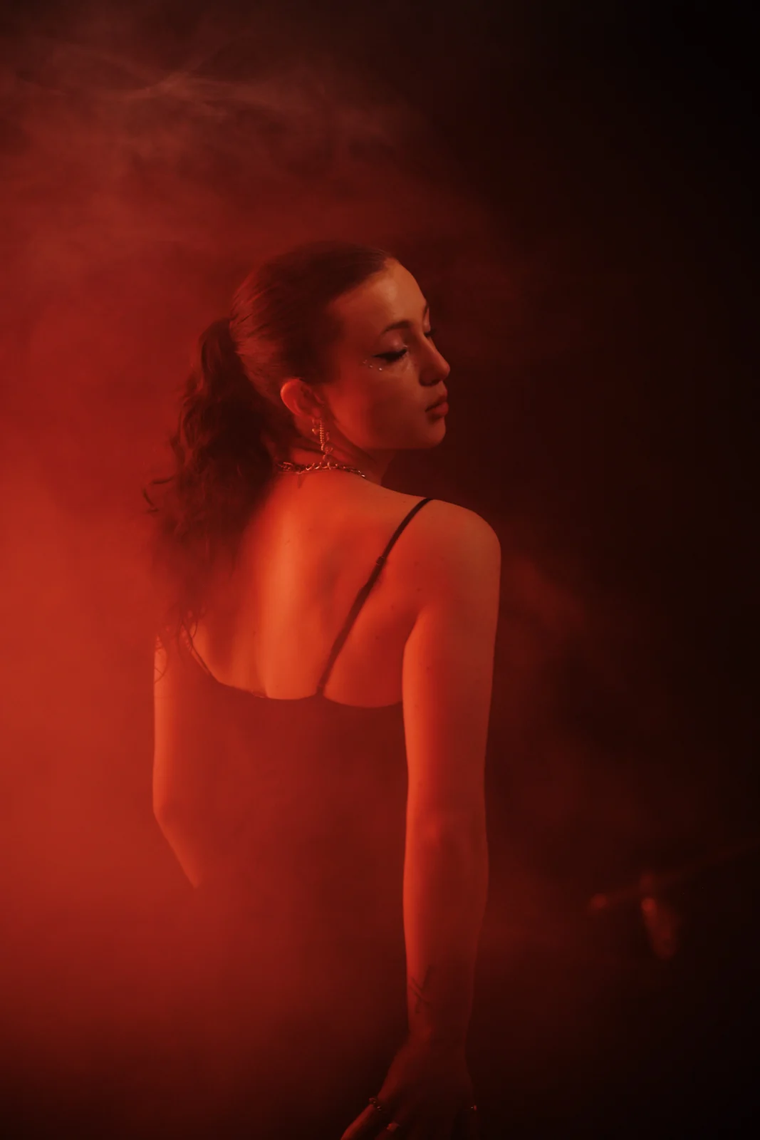 Portrait in red light and drifting haze