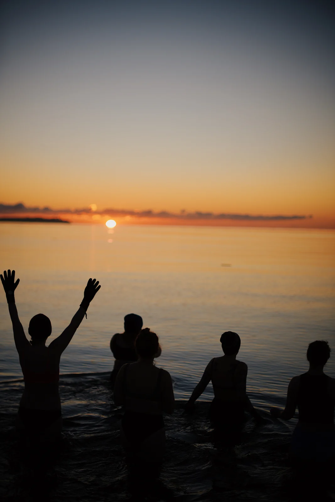 Swimmers greeting sunrise in the ocean
