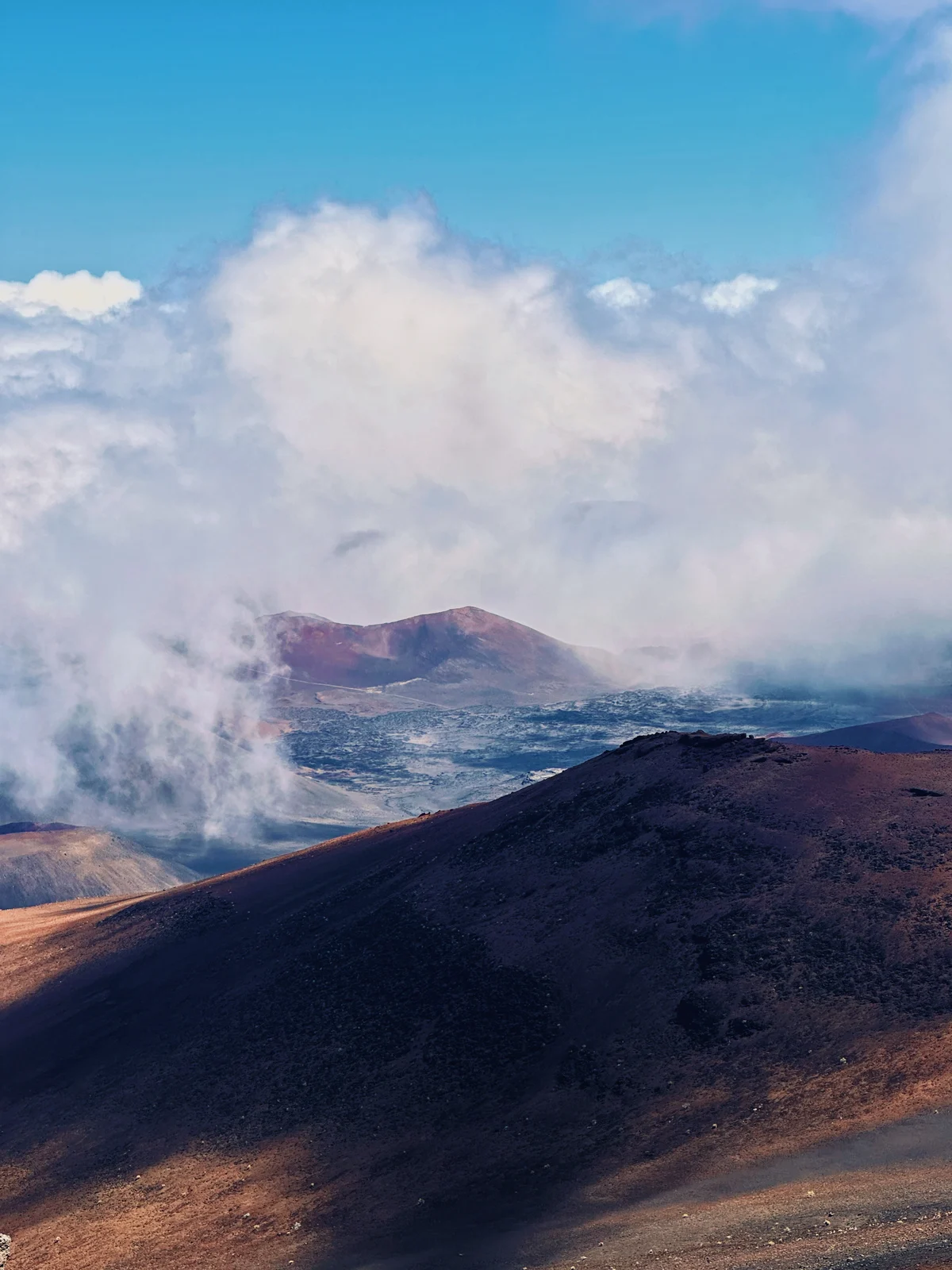Clouds rising above a volcanic mountain