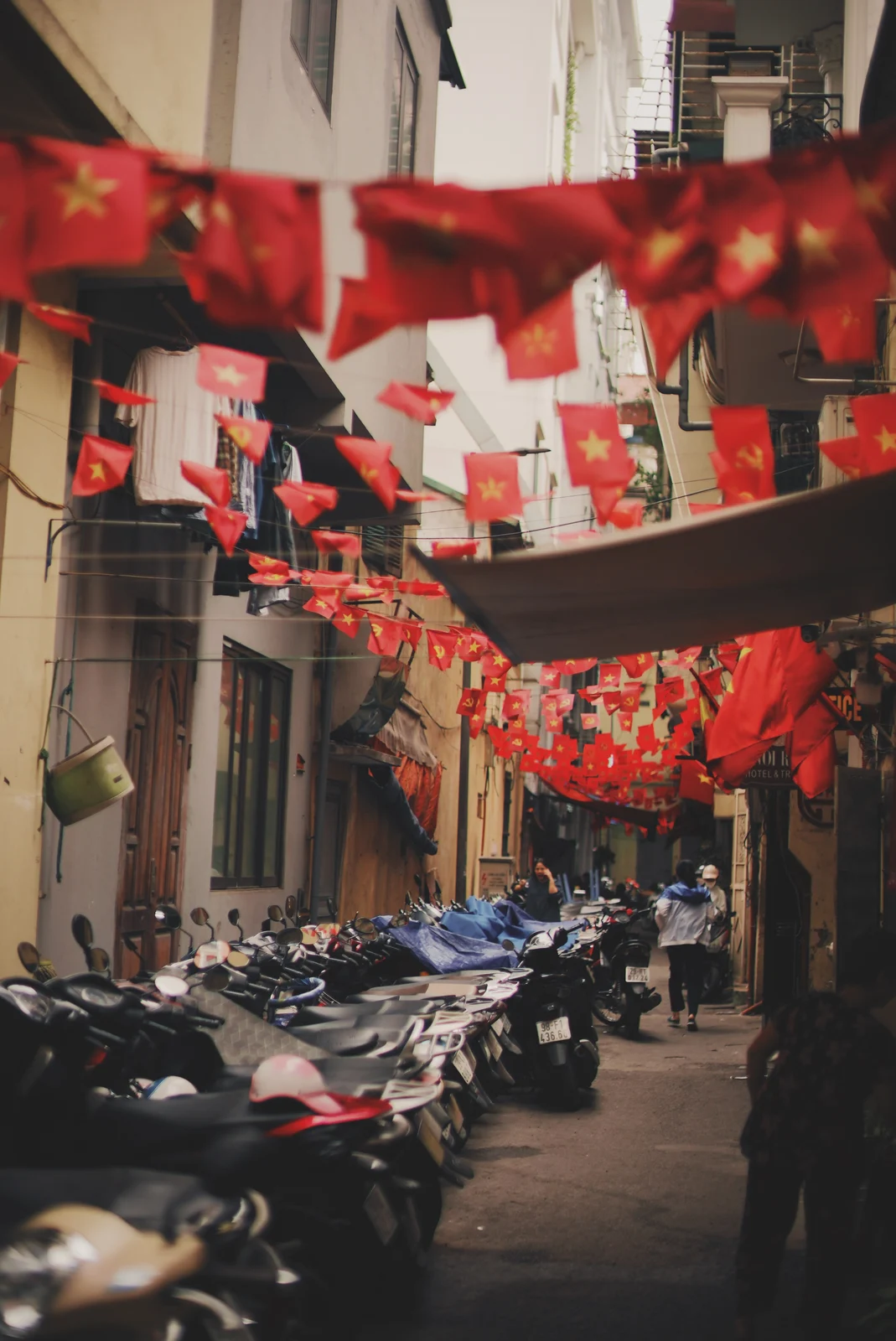 Red flags above a narrow street and motorcycles