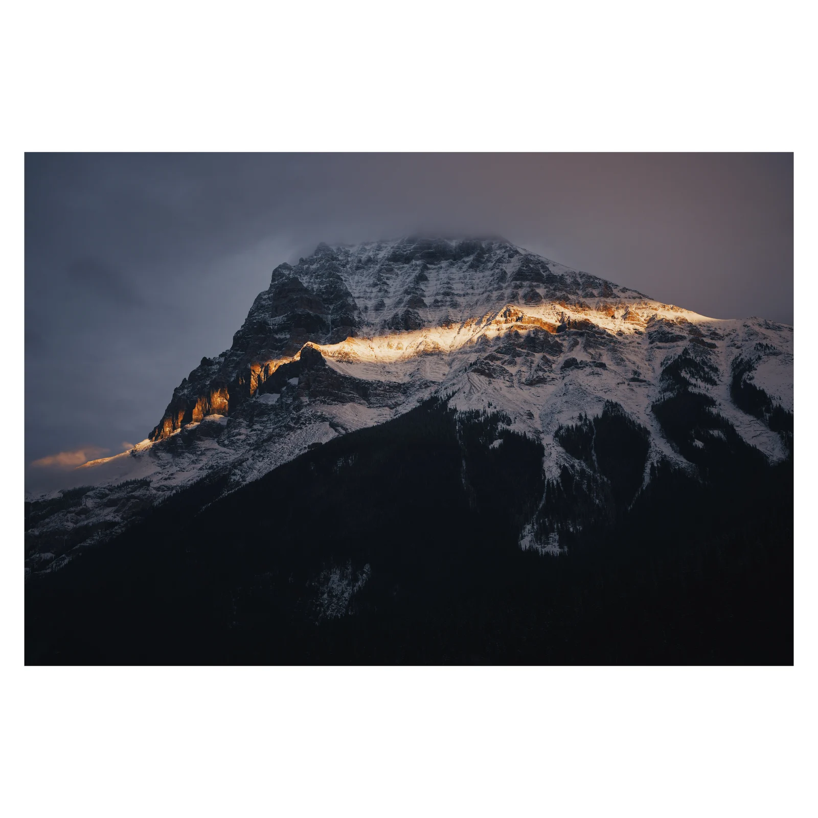 Evening sunlight across a dark mountain face