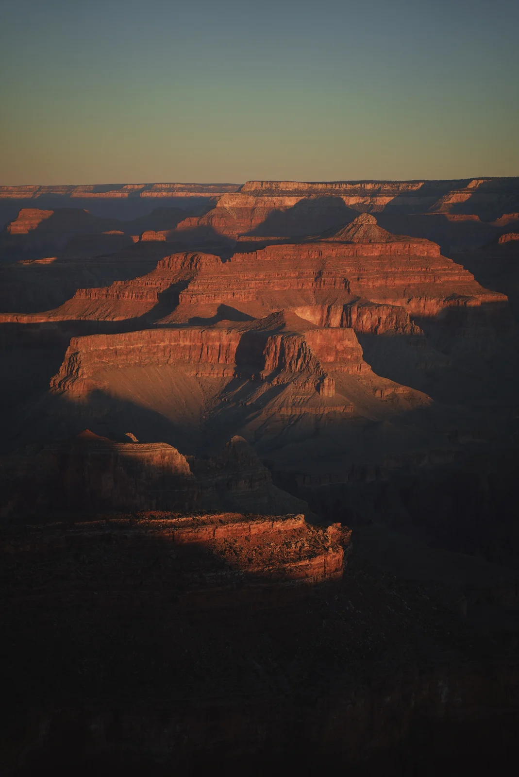 Orange canyon ridges beneath a pale blue sky